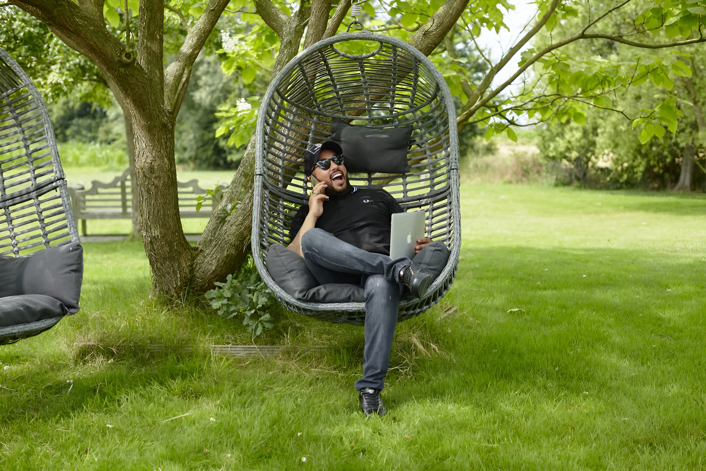 Portrait de DJ Youcef assis dans un jardin