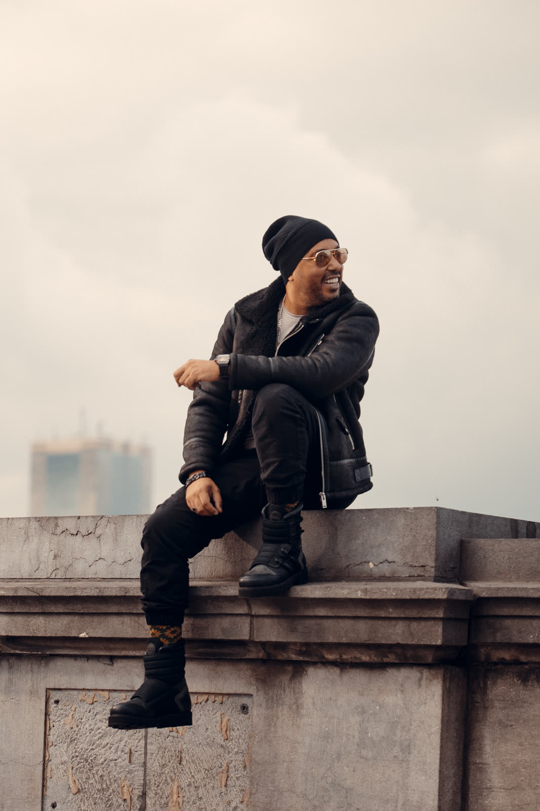 Portrait de DJ Youcef en extérieur avec un bonnet noir